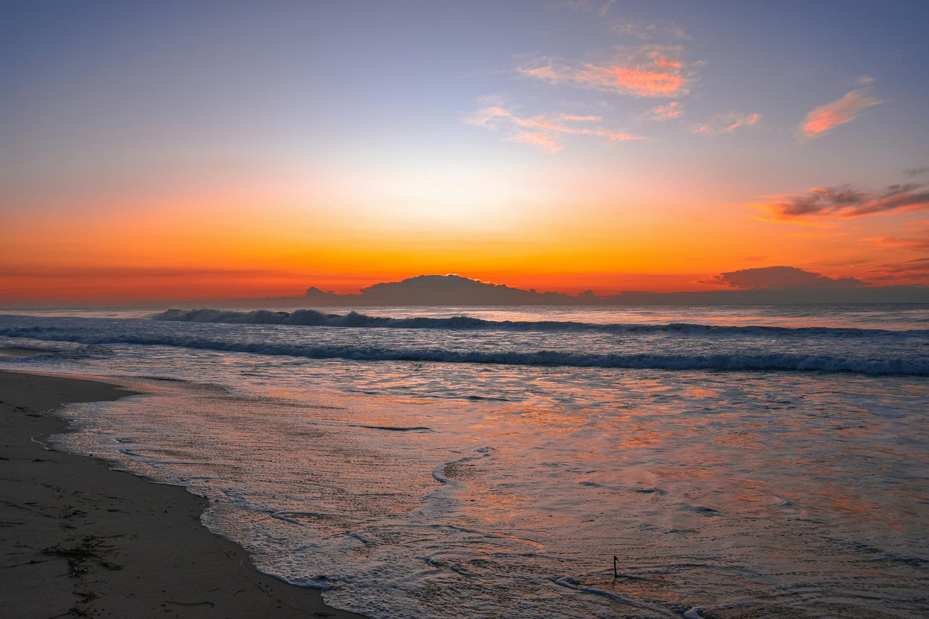 Wschód słońca nad spokojnym morzem w Sztutowie, barwy na tafli wody