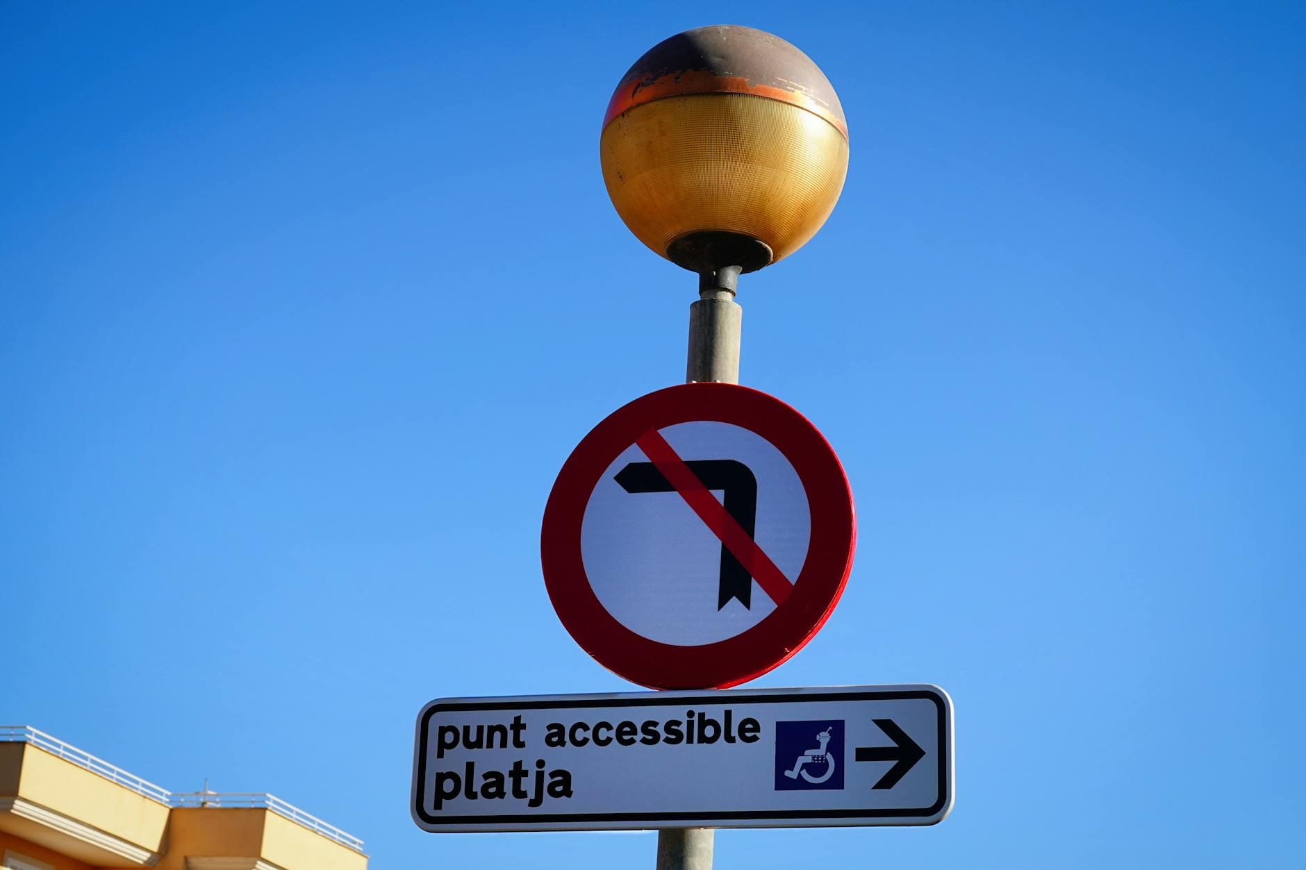 Znak zakazu skrętu w lewo i kierunek na plażę przy drodze