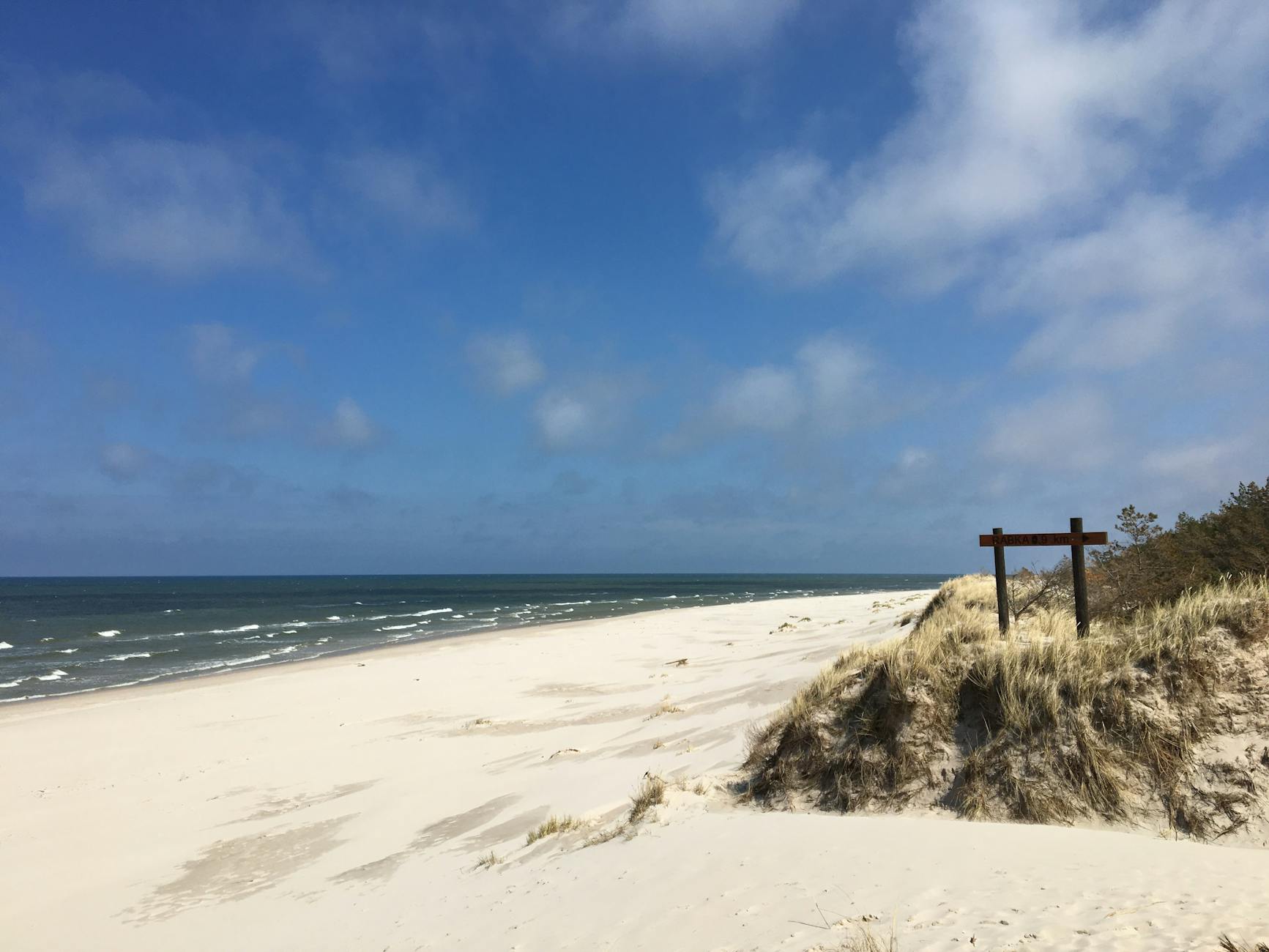 Słowińskie wydmy w Łebie i pusta plaża pod błękitnym niebem