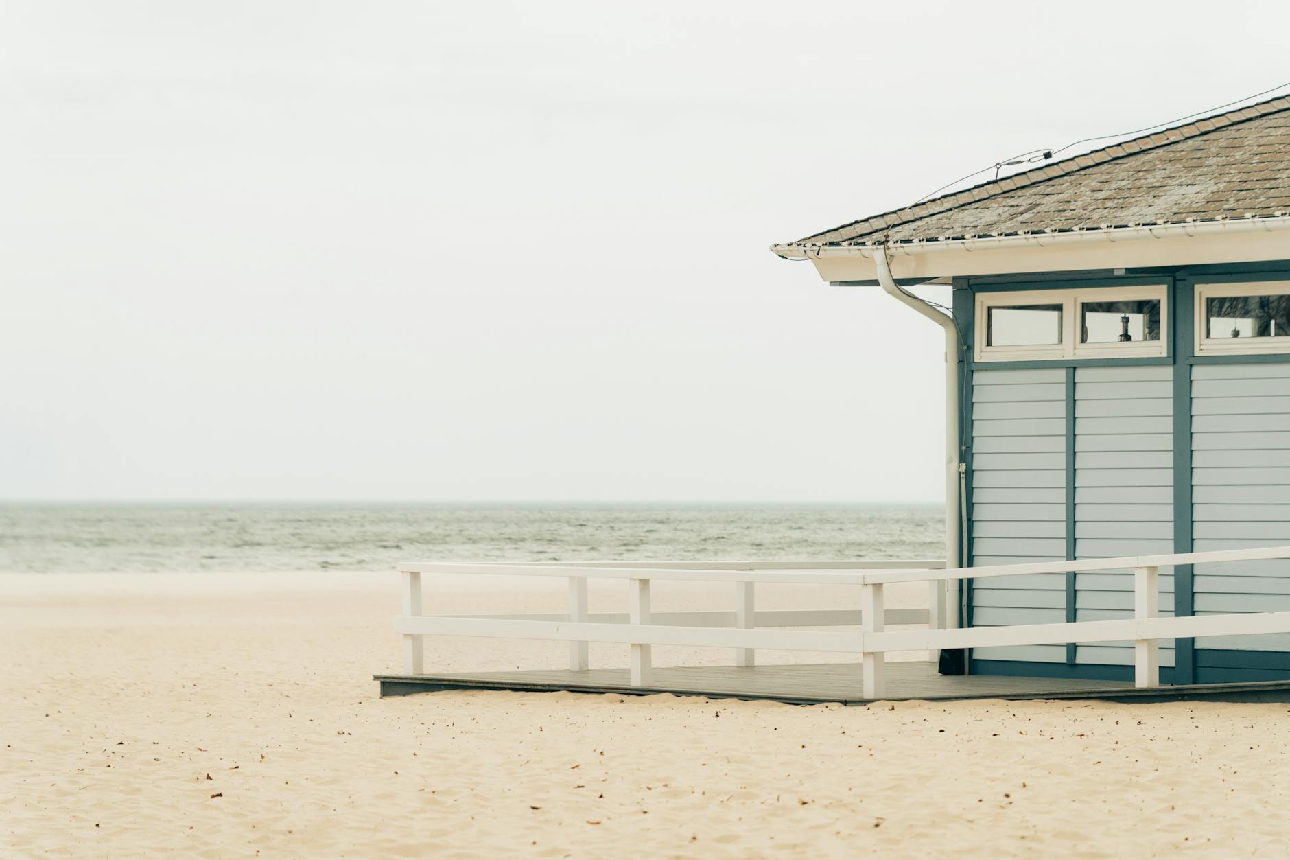 Pusty bałtycki brzeg z drewnianą budką plażową o świcie