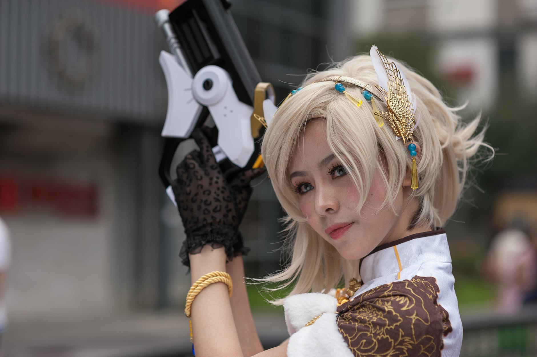 Cosplayer w szczegółowym stroju z repliką broni pozuje na dworze