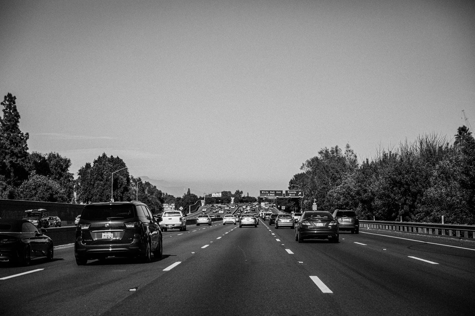 Czarnobiały korek na autostradzie z widocznymi znakami drogowymi