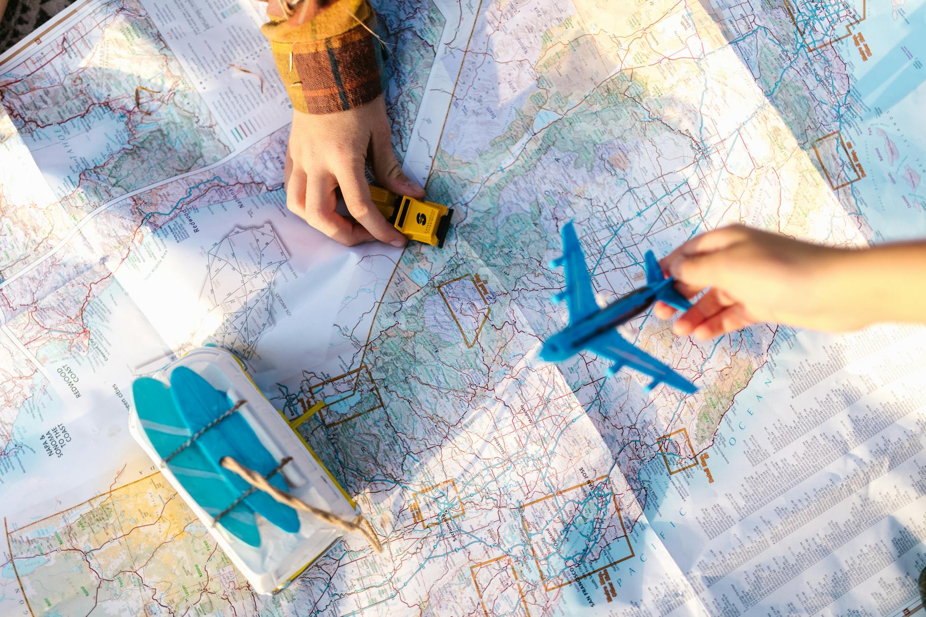 Jak dojechać do Sztutowa z Poznania: sprawdzony plan podróży i postoje Dłonie trzymające zabawkowy samolot i auto nad mapą trasy podróży
