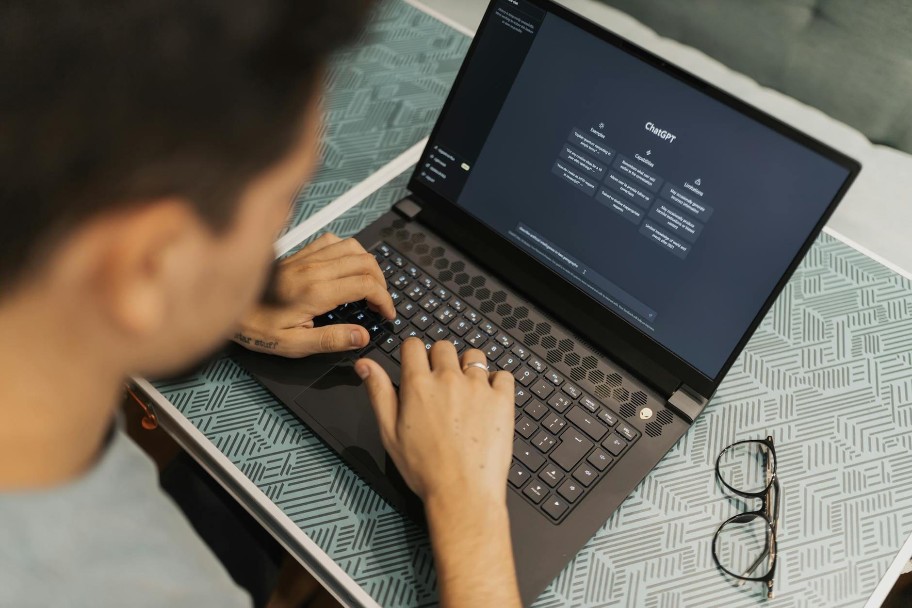 Nauczyciel w okularach pracuje na laptopie z oprogramowaniem AI