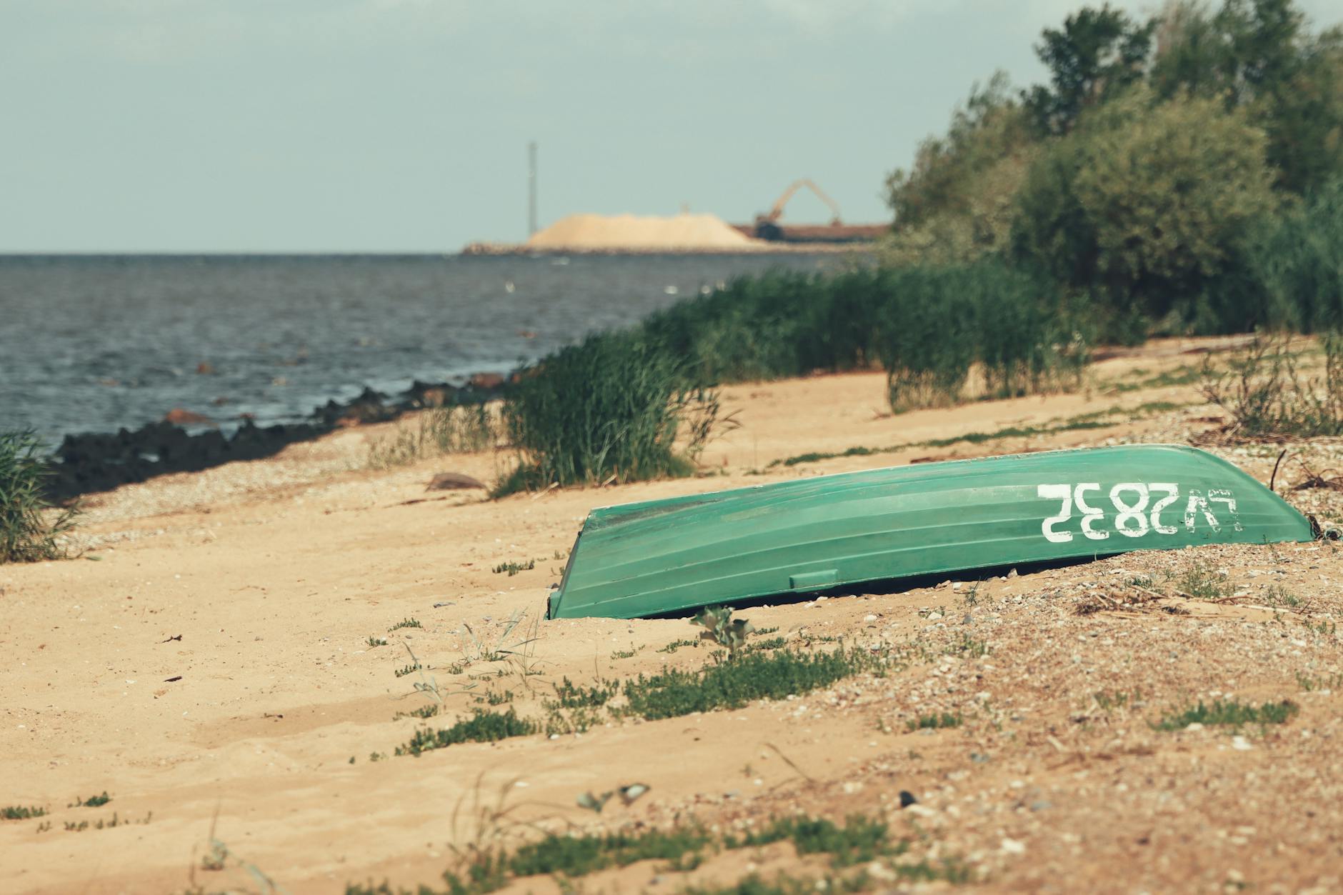 Odwrócona łódź na spokojnej, piaszczystej plaży nad Bałtykiem