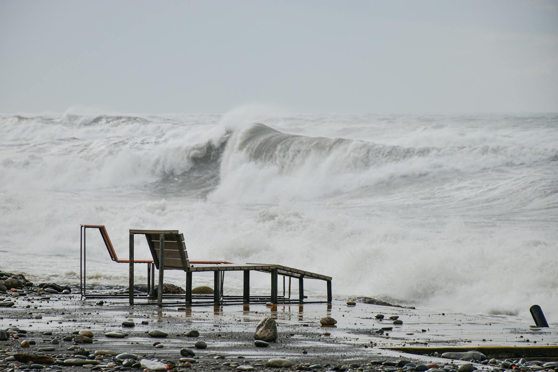 Sztormowe fale w Sztutowie uderzające o plażę z pustymi leżakami