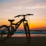 Rowerem na zachód słońca: trasa na plażę w Sztutowie Rower na plaży w Sztutowie o zachodzie słońca