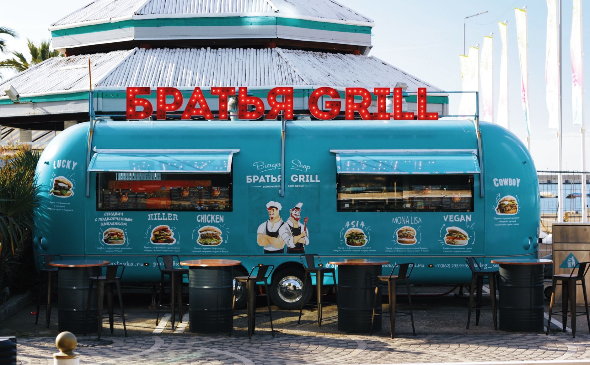 Niebieski food truck z rosyjskimi napisami w słonecznym kurorcie